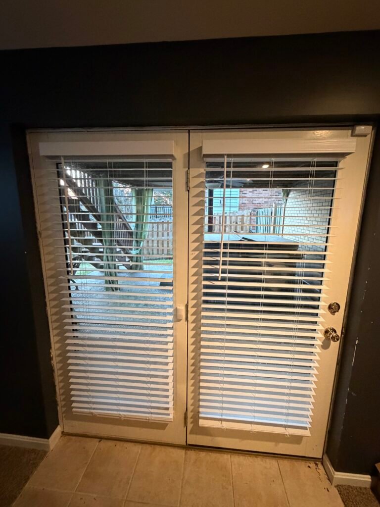 Clean blinds installation over double doors for privacy and light control