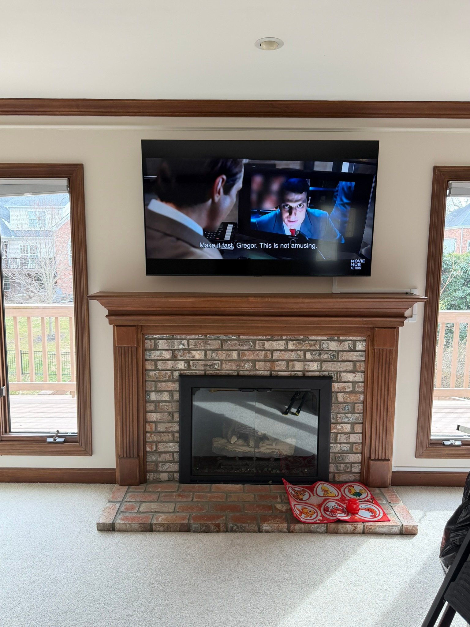 Real TV Mounting Installations: Photos and Project Notes Mounted TV above a wood mantel and brick-faced fireplace, with matching windows on both sides