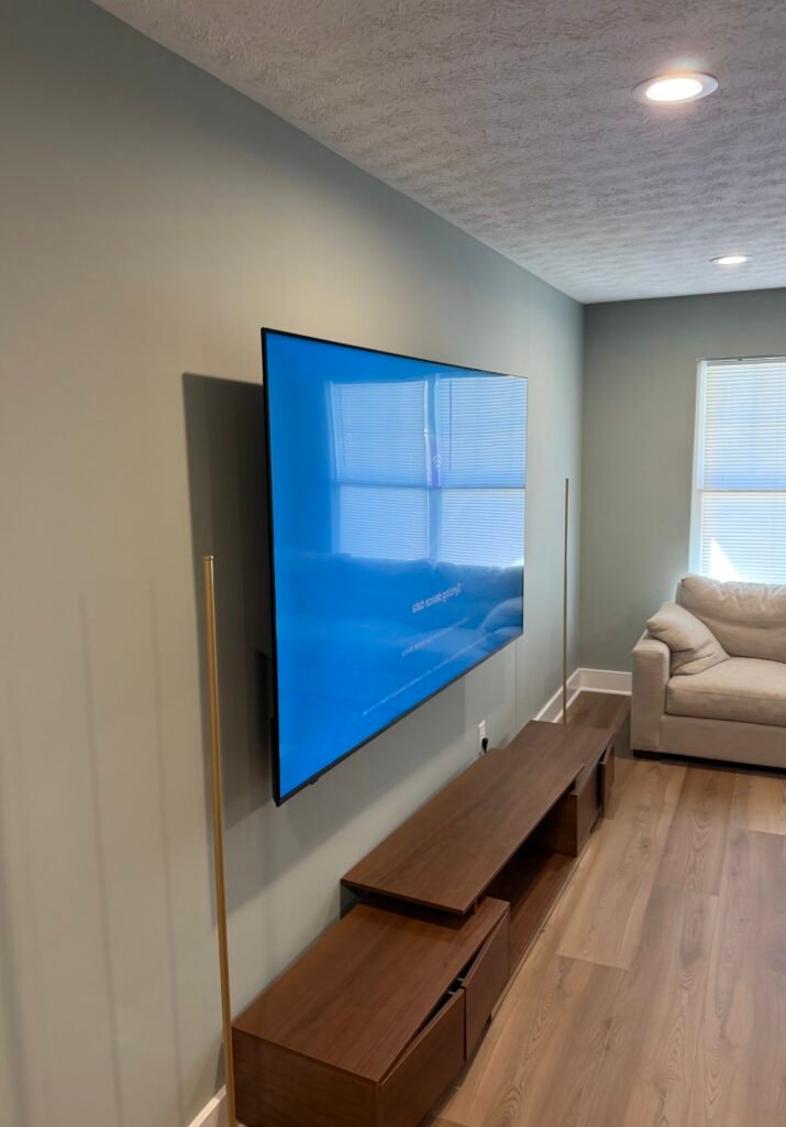TV mounting with in-wall cable kit showing clean cable exit below wall and hidden wires behind 89 inch TV