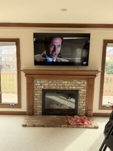 Wall-mounted TV above a fireplace mantel