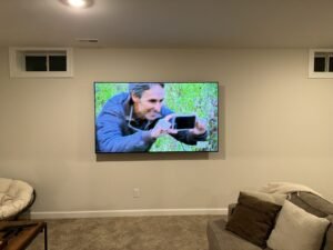 TV on a living room wall above a media console