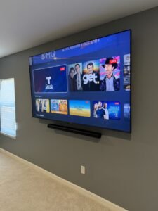 Large TV with soundbar on a gray wall