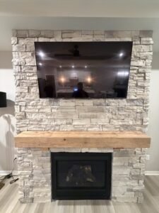 TV mounted above a stone-faced fireplace