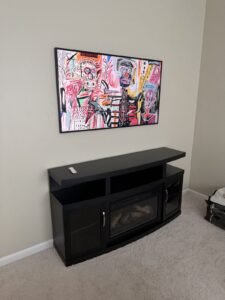 Art TV above a black electric fireplace media console