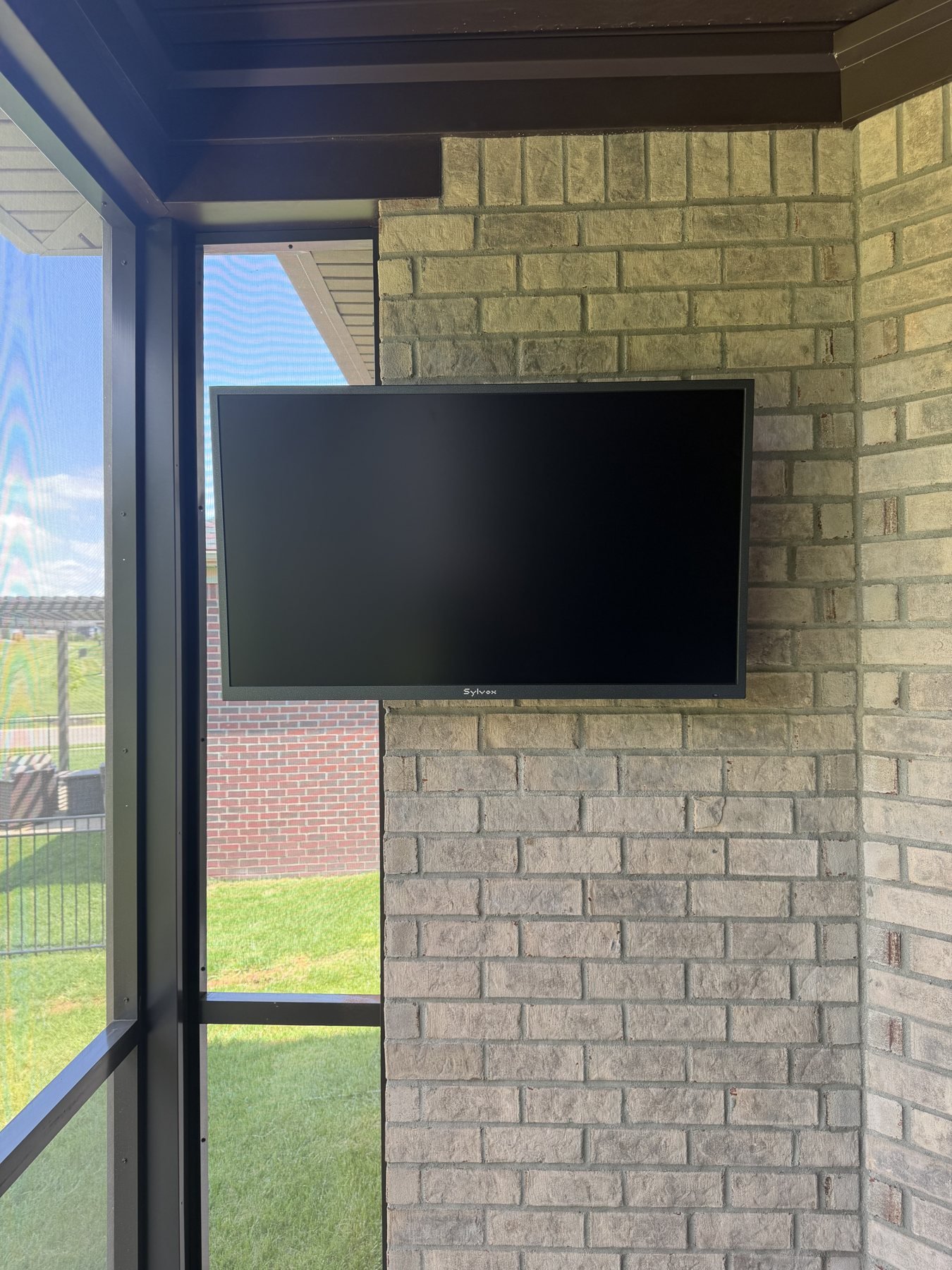 Outdoor TV Mounting on Covered Brick Porches Wall-mounted TV on brick beneath a covered porch roof