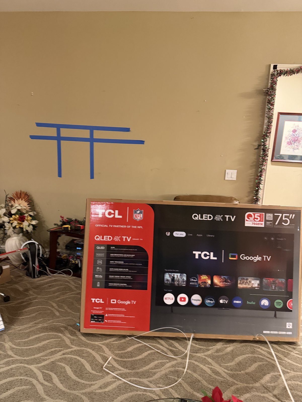 Blue tape marking a planned TV position beside a 75 inch TCL box in Shelbyville, Kentucky